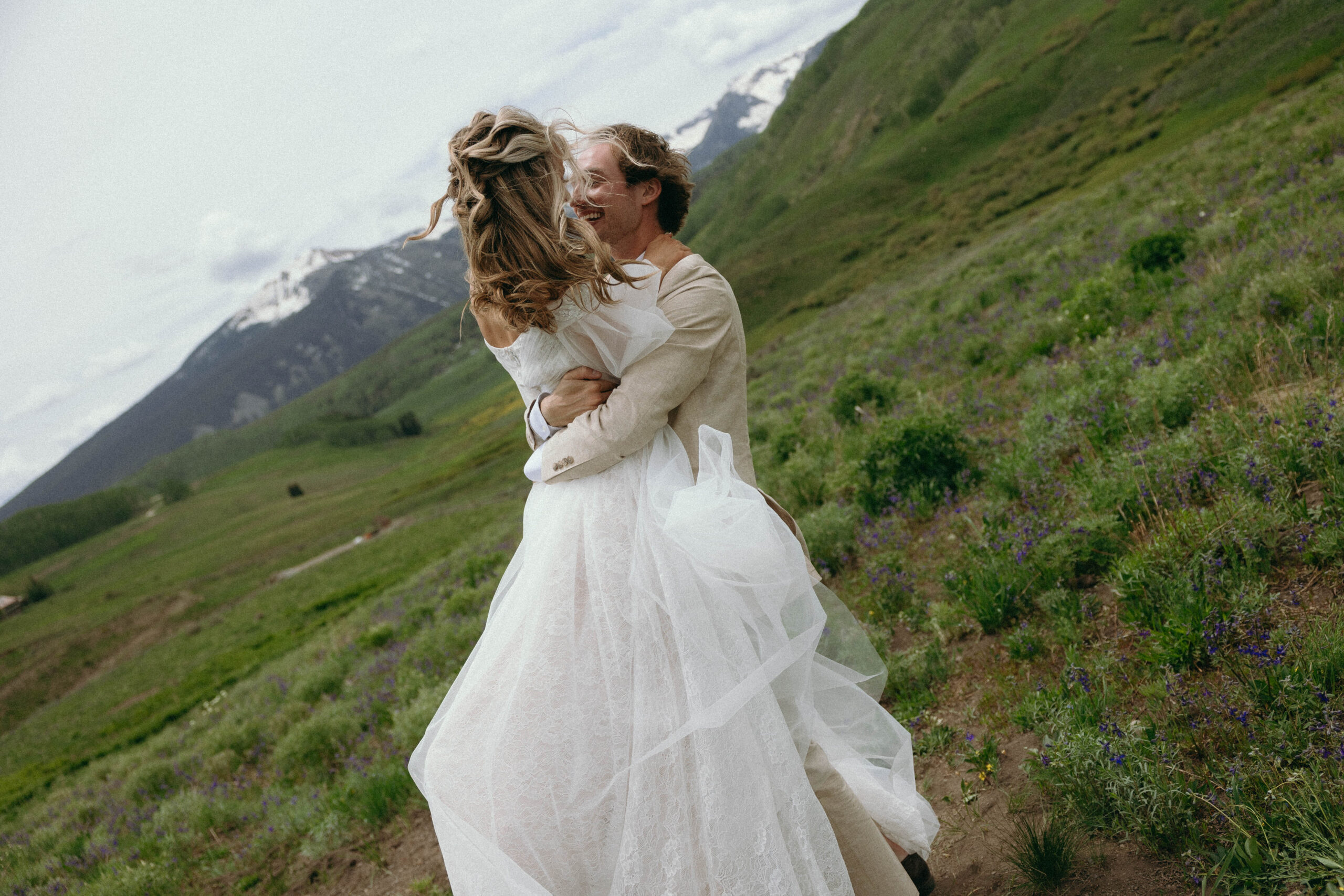 A skilled wedding photographer capturing a beautiful outdoor ceremony with a bride and groom amidst stunning mountain scenery in Colorado.