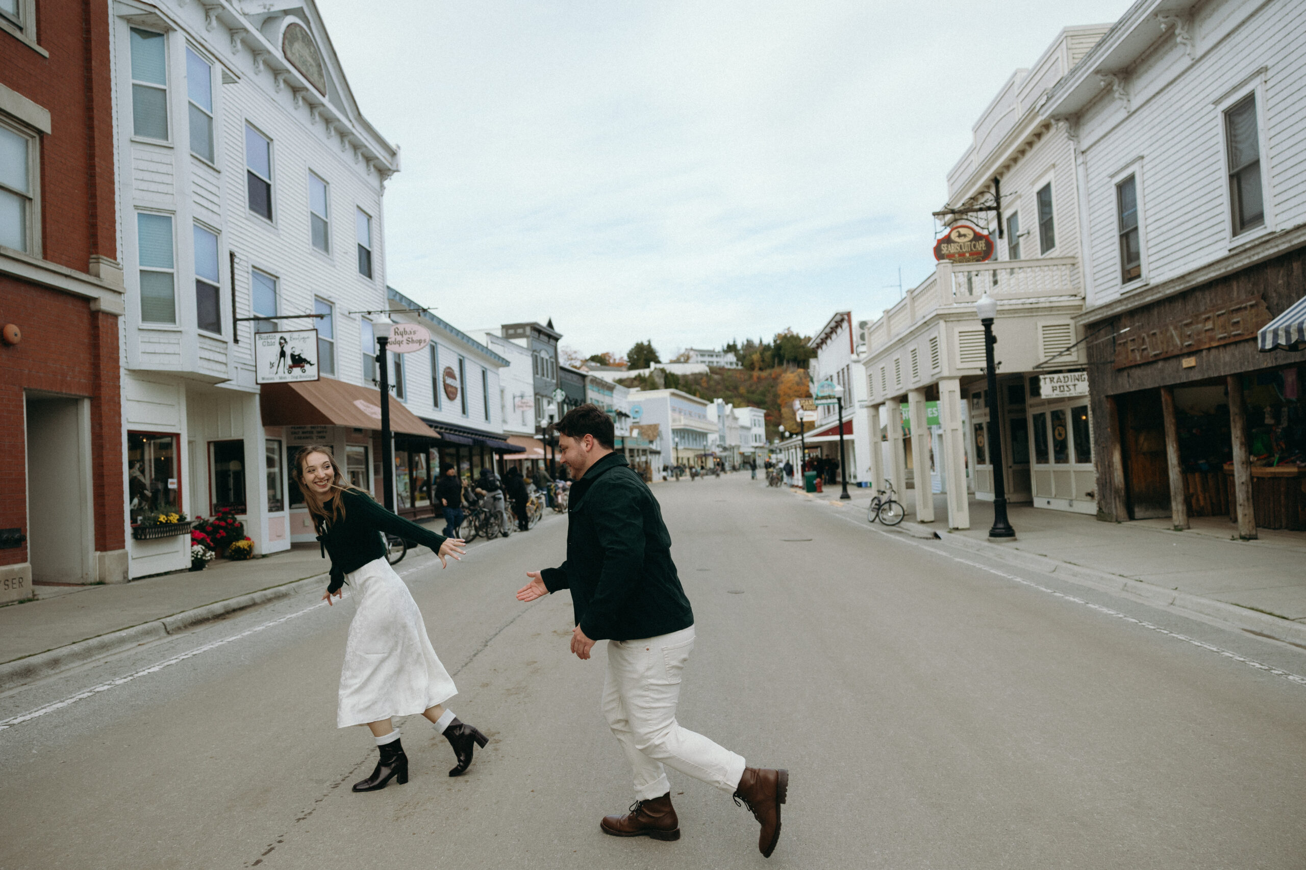 A couple runs across a street on Mackinac Island hand in hand, expressing their love for one another.