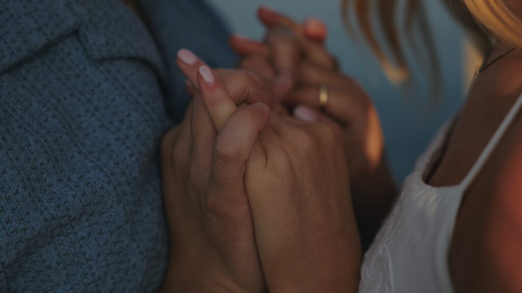 A woman gently places her hand on a man's hand, symbolizing expressing intimacy and emotional bond in their relationship.